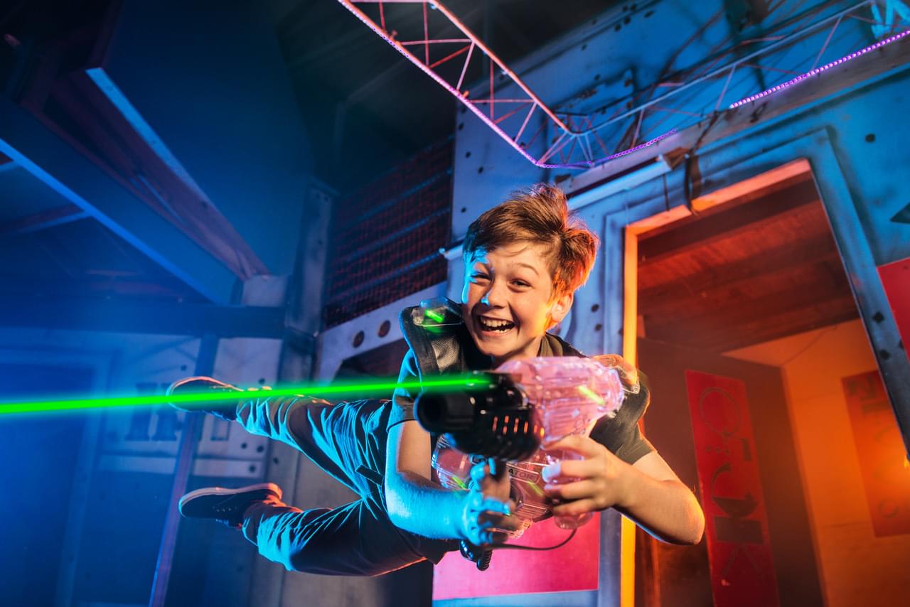 Junge springt durch Lasertag Halle