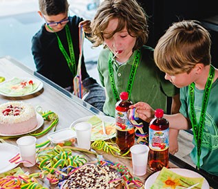 Kinder essen Kuchen am gedeckten Geburtstagstisch beim LaserTag in Düsseldorf